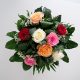 Ein Rosenstrauß mit roten, weißen, pinken und orangenen Rosen mit viel Grün von oben.